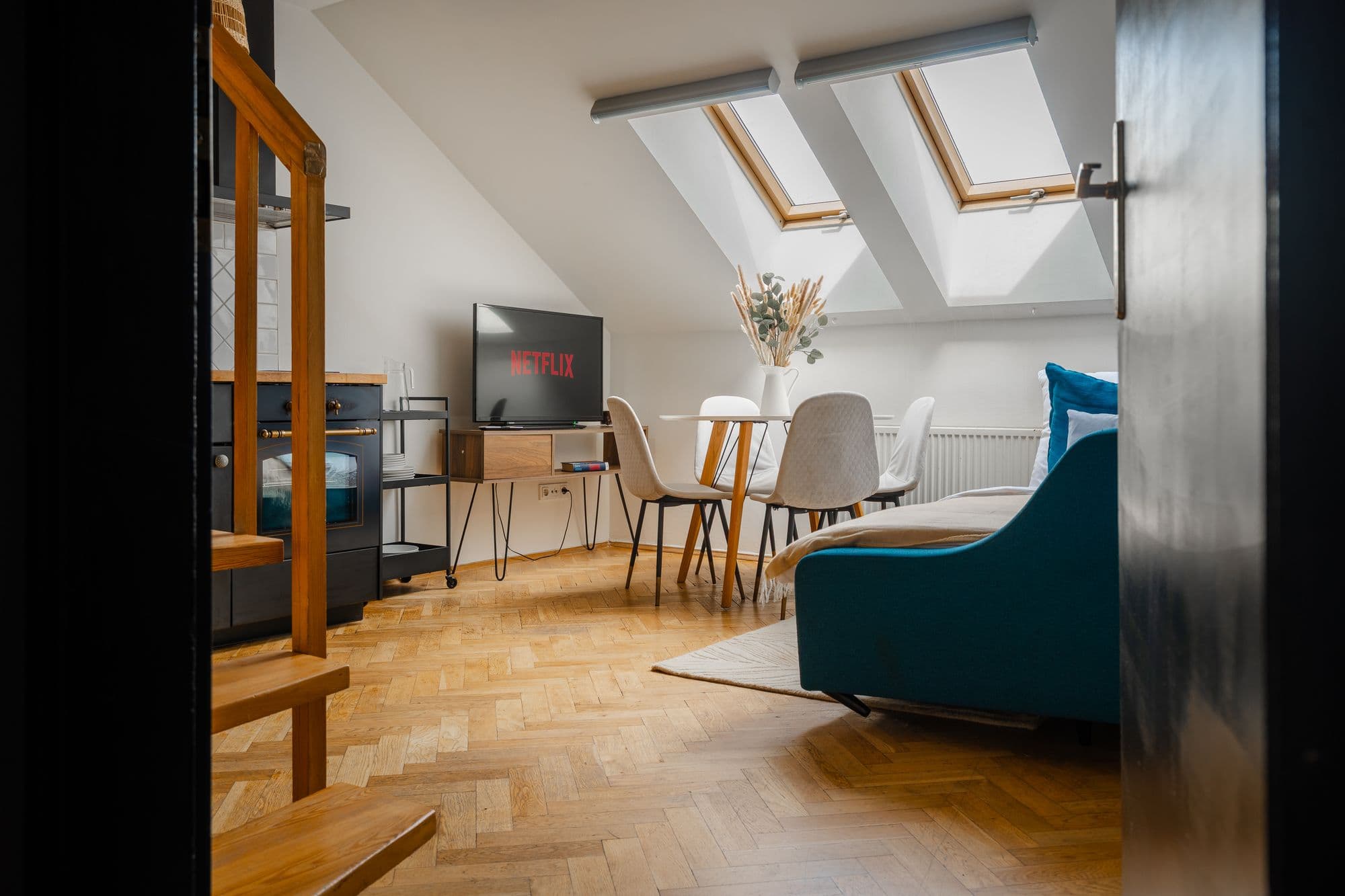 Attic living room lit by two skylights, framed by a dark doorway.